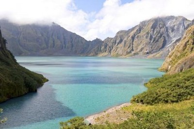 游客在皮納圖博火山湖遠足和在碧藍透徹的湖水里游泳